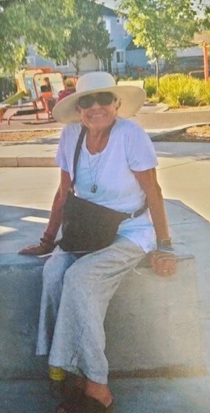 Woman with hat sitting outdoors